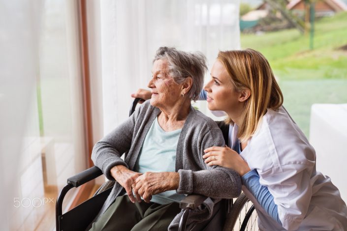 Health visitor and a senior woman during home visit.